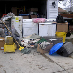 Soaked, wet personal items sitting in a driveway, including a washer and dryer in Stratford.